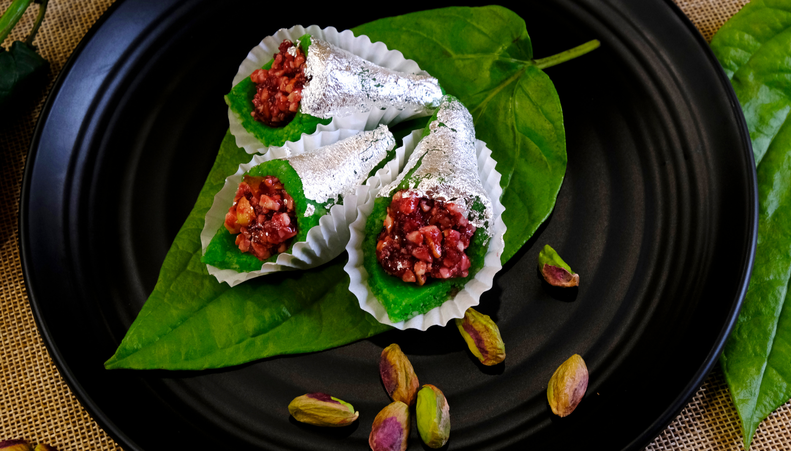 Fresh betel leaf filled with a sweet blend of gulkand, fennel seeds, coconut, and tutti frutti, gently folded and served as a traditional after-meal delight.